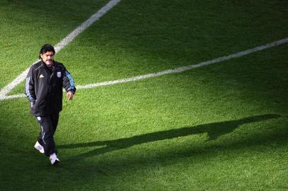 98697118(FILES) In this file photo taken on July 03, 2010 Argentinas coach Diego Maradona walks on the pitch as the teams warm up before the 2010 World Cup quarter-final football match between Argentina and Germany at Green Point stadium in Cape Town. Germany won 4-0 to advance to the semi-finals. - Argentine football legend Diego Maradona has died at the age of 60, his spokesman announced on November 25, 2020.Renowned with Brazils Pele as one of the greatest footballers of all time, the Argentine World Cup winning captain died of a heart attack, having undergone brain surgery earlier this month, a member of his entourage told AFP. (Photo by Christophe SIMON / AFP)Editoria: SPOLocal: Cape TownIndexador: CHRISTOPHE SIMONSecao: soccerFonte: AFPFotógrafo: STF<!-- NICAID(14652143) -->