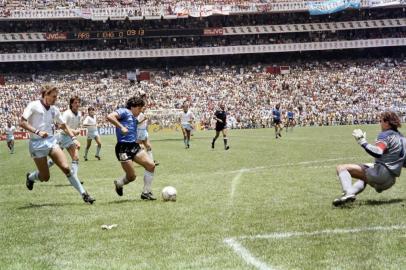  (FILES) In this file photo taken on June 22, 1986 Argentinian forward Diego Armando Maradona (3rd L) runs past English defender Terry Butcher (L) on his way to dribbling goalkeeper Peter Shilton (R) and scoring his second goal, or goal of the century, during the World Cup quarterfinal football match between Argentina and England in 1986 in Mexico City. - Argentinian football legend Diego Maradona passed away on November 25, 2020 (Photo by STAFF / AFP)Editoria: SPOLocal: Mexico CityIndexador: STAFFSecao: soccerFonte: AFPFotógrafo: STF<!-- NICAID(14652365) -->