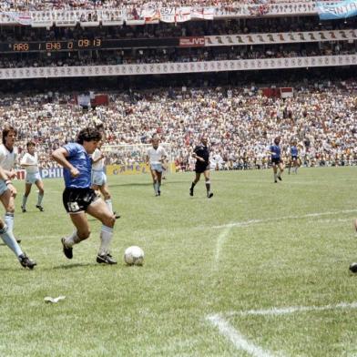  (FILES) In this file photo taken on June 22, 1986 Argentinian forward Diego Armando Maradona (3rd L) runs past English defender Terry Butcher (L) on his way to dribbling goalkeeper Peter Shilton (R) and scoring his second goal, or goal of the century, during the World Cup quarterfinal football match between Argentina and England in 1986 in Mexico City. - Argentinian football legend Diego Maradona passed away on November 25, 2020 (Photo by STAFF / AFP)Editoria: SPOLocal: Mexico CityIndexador: STAFFSecao: soccerFonte: AFPFotógrafo: STF<!-- NICAID(14652365) -->