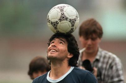 MARADONAArgentine soccer star Diego Maradona, wearing a diamond earring, balances a soccer ball on his head as he walks off the practice field following the national selections 22 May 1986 practice session in Mexico City. (Photo by JORGE DURAN / AFP)Editoria: SPOLocal: Mexico CityIndexador: JORGE DURANSecao: soccerFonte: AFPFotógrafo: STR<!-- NICAID(14652370) -->