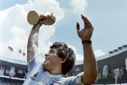  Argentinas soccer star team captain Diego Maradona brandishes the World Soccer Cup won by his team after a 3-2 victory over West Germany on June 29, 1986 at the Azteca stadium in Mexico City. (Photo by STAFF / AFP)Editoria: SPOLocal: Mexico CityIndexador: STAFFSecao: soccerFonte: AFP<!-- NICAID(14652367) -->