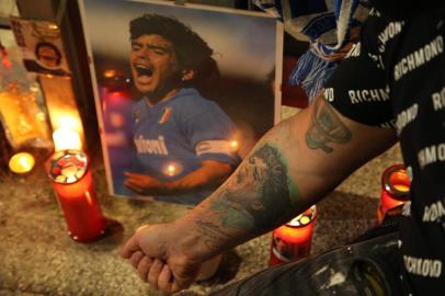  A view shows a makeshift shrine set up at the main entrance of the San Paolo stadium in Naples on November 25, 2020 with an image of Argentinian football legend Diego Maradona, as people gather to mourn after the annoucements of Maradonas death. - Argentine football legend Diego Maradona has died at the age of 60, his spokesman announced November 25, 2020. (Photo by CARLO HERMANN / AFP)Editoria: SPOLocal: NaplesIndexador: CARLO HERMANNSecao: soccerFonte: AFPFotógrafo: STR<!-- NICAID(14652580) -->