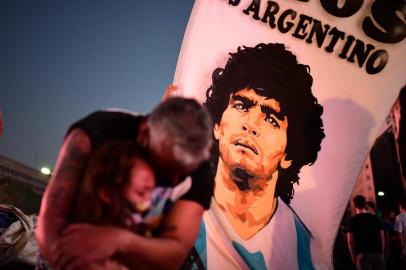  A father and her daughter, fans of Argentinian football legend Diego Maradona, mourn as they gather by the Obelisk to pay homage on the day of his death in Buenos Aires, on November 25, 2020. - The body of Argentine football legend Diego Maradona, who died earlier today, will lie in state at the presidential palace in Buenos Aires during three days of national mourning, the presidency announced. (Photo by RONALDO SCHEMIDT / AFP)Editoria: SPOLocal: Buenos AiresIndexador: RONALDO SCHEMIDTSecao: soccerFonte: AFPFotógrafo: STF<!-- NICAID(14652857) -->