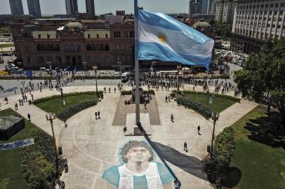  Aerial view of the Argentinian flag at half mast at Mayo sqaure next to a drawing on the pavement as people queue along Avenida de Mayo avenue to reach the Casa Rosada presidential palace to pay tribute to late Argentine football legend Diego Maradona in Buenos Aires in November 26, 2020. - Argentine football legend Diego Maradona will be buried Thursday on the outskirts of Buenos Aires, a spokesman said. Maradona, who died of a heart attack Wednesday at the age of 60, will be laid to rest in the Jardin de Paz cemetery, where his parents were also buried, Sebastian Sanchi told AFP. (Photo by Ivan PISARENKO / AFP)Editoria: SPOLocal: Buenos AiresIndexador: IVAN PISARENKOSecao: soccerFonte: AFPFotógrafo: STF<!-- NICAID(14653405) -->