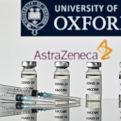  (FILES) In this file photo taken on November 17, 2020 An illustration picture shows vials with Covid-19 Vaccine stickers attached and syringes, with the logo of the University of Oxford and its partner British pharmaceutical company AstraZeneca. - British drugs group AstraZeneca and the University of Oxford on November 23, 2020 said their jointly-developed vaccine against Covid-19 has shown an average efficacy of 70 percent in trials. The results ranged between 62 and 90 percent efficacy depending on the vaccine dosage. (Photo by JUSTIN TALLIS / AFP)Editoria: HTHLocal: LondonIndexador: JUSTIN TALLISSecao: epidemic and plagueFonte: AFPFotógrafo: STF<!-- NICAID(14650449) -->