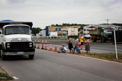  SAPUCAIA DO SUL, RS, BRASIL, 30-11-2020: Kauane Francieli (D) e outras pessoas se arriscam para atravessar a RS-118, com transito intenso, perto da rua Alcebiades Tavares. Obras de duplicacao da RS-118, trecho de 22 quilometros entre a BR-116 e a BR-290, a Freeway, entre Sapucaia do Sul e Gravatai.  (Foto: Mateus Bruxel / Agencia RBS)Indexador: Mateus Bruxel<!-- NICAID(14656776) -->