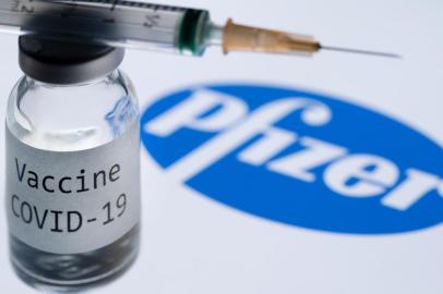  (FILES) In this file photo taken on November 23, 2020 This illustration picture taken in Paris on November 23, 2020 shows a syringe and a bottle reading Covid-19 Vaccine next to the Pfizer company logo. - Britain on December 2, 2020 became the first country to approve Pfizer-BioNTechs Covid-19 vaccine for general use and said it would be introduced next week. (Photo by JOEL SAGET / AFP)Editoria: HTHLocal: ParisIndexador: JOEL SAGETSecao: epidemic and plagueFonte: AFPFotógrafo: STF<!-- NICAID(14659601) -->