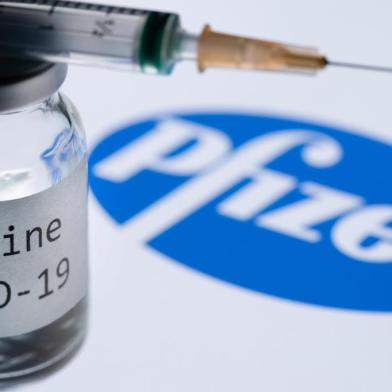  (FILES) In this file photo taken on November 23, 2020 This illustration picture taken in Paris on November 23, 2020 shows a syringe and a bottle reading "Covid-19 Vaccine" next to the Pfizer company logo. - Britain on December 2, 2020 became the first country to approve Pfizer-BioNTech's Covid-19 vaccine for general use and said it would be introduced next week. (Photo by JOEL SAGET / AFP)Editoria: HTHLocal: ParisIndexador: JOEL SAGETSecao: epidemic and plagueFonte: AFPFotógrafo: STF<!-- NICAID(14659601) -->