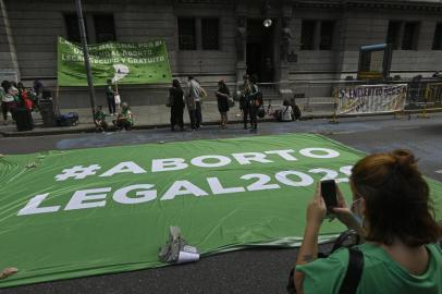 A pro-abortion supporter takes a picture of a banner reading Legal abortion 2020 during a demo outside the Congress building in Buenos Aires on December 4, 2020, where commissions discuss a bill to legalize abortion that is expected to be voted in the lower chamber next week. (Photo by JUAN MABROMATA / AFP)<!-- NICAID(14665320) -->