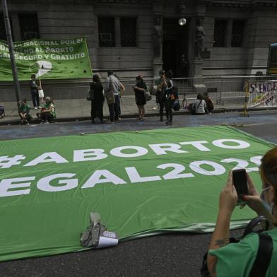 A pro-abortion supporter takes a picture of a banner reading Legal abortion 2020 during a demo outside the Congress building in Buenos Aires on December 4, 2020, where commissions discuss a bill to legalize abortion that is expected to be voted in the lower chamber next week. (Photo by JUAN MABROMATA / AFP)<!-- NICAID(14665320) -->