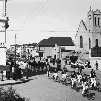 Desfile de alunos do Colégio Nossa Senhora do Carmo pela Júlio de Castilhos, esquina com Marechal Floriano, por volta de 1943. Imagem integrante do livro O Outro Lado da Júlio, de Roberto Filippini. Ao fundo vê-se a Igreja Metodista e o prédio da antiga Companhia Telefônica Riograndense - atual Magazine Luiza. À direita, o antigo prédio conhecido por Palacete das Damas de Caridade do Hospital Pompéia. Demolido nos anos 1960, ele deu lugar ao novo prédio do hospital, na esquina com a Marechal Floriano.<!-- NICAID(14666360) -->