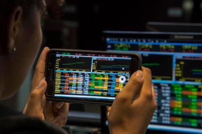  A visitor take pictures of a screen at the Sao Paulo Stock Exchange (B3), in Sao Paulo, Brazil, on May 18, 2017.Brazilian financial markets plummeted on opening Thursday in the wake of a bombshell report that President Michel Temer approved paying hush money to a corrupt politician. The real fell 5.46 percent against the dollar to 3.315, down from 3.134 at closing Wednesday, CMA consultants said. / AFP PHOTO / Nelson ALMEIDAEditoria: FINLocal: Sao PauloIndexador: NELSON ALMEIDASecao: foreign exchange marketFonte: AFPFotógrafo: STF<!-- NICAID(12920151) -->