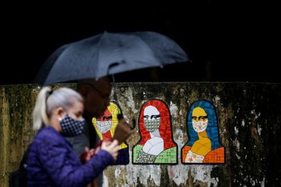 PORTO ALEGRE, RS, BRASIL, 12-05-2020: Obra com monalisas mascaradas na rua Fernando Machado. Movimentação na região central em dia de chuva. (Foto: Mateus Bruxel / Agência RBS)<!-- NICAID(14498058) -->