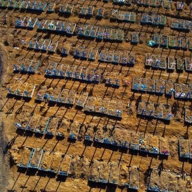  Aerial view showing a man walking past graves in the Nossa Senhora Aparecida cemetery in Manaus on June 21, 2020. - The novel coronavirus has killed at least 464,423 people worldwide since the outbreak began in China last December, being Brazil Latin Americas worsthit country with 49,976 deaths from 1,067,579 cases. (Photo by MICHAEL DANTAS / AFP)Editoria: HTHLocal: ManausIndexador: MICHAEL DANTASSecao: diseaseFonte: AFPFotógrafo: STR<!-- NICAID(14527400) -->