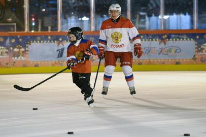 Russian President Vladimir Putin plays ice hockey with Dmitry Ashchepkov from Chelyabinsk at an outdoor ice skating rink in Red Square during the Christmas Tree of Wishes campaign, in Moscow on December 21, 2020. - Vladimir Putin fulfills the wishes of Russian children during the run-up to Christmas and New Year. (Photo by Alexey NIKOLSKY / SPUTNIK / AFP)<!-- NICAID(14674593) -->