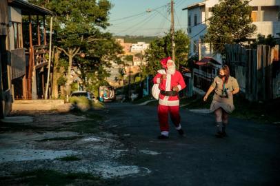  PORTO ALEGRE, RS, BRASIL - 17/12/2020Papai Noel da Lomba do Pinheiro - Julio Cesar Mello da Silva, 34 anos, se veste de Papai Noel no dia 24 de dezembro para distribuir doces, presentes e abraços para crianças do entorno da sua casa, na Lomba do Pinheiro, há quatro anos. Neste ano, em função da pandemia e por falta de dinheiro, a ação não seria feita. Mas voluntários de um grupo de escoteiros estão reunindo doações, e o papai noel da Lomba andará pelo bairro mais este ano. Na foto, Julio e a filha Brenda<!-- NICAID(14671605) -->