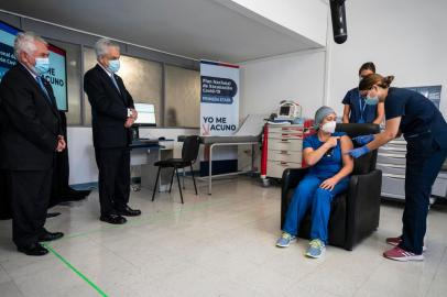  Handout picture released by Chiles Presidency of President Sebastian Pinera (2-L) looking at Chilean nurse Zulema Riquelme receiving the first of two Pfizer/BioNTech Covid-19 vaccine jabs, at the Metropolitano Hospital in Santiago, on December 24, 2020. - A flight carrying 10,000 vaccines produced by Pfizer/BioNTech arrived at Santiago airport in the Chilean capital on Thursday morning. (Photo by marcelo segura / CHILES PRESIDENCY / AFP) / RESTRICTED TO EDITORIAL USE - MANDATORY CREDIT AFP PHOTO / CHILES PRESIDENCY / Marcelo SEGURA  - NO MARKETING - NO ADVERTISING CAMPAIGNS - DISTRIBUTED AS A SERVICE TO CLIENTSEditoria: HTHLocal: SantiagoIndexador: MARCELO SEGURASecao: diseaseFonte: CHILES PRESIDENCYFotógrafo: Handout<!-- NICAID(14676654) -->