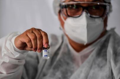  A doctor shows a vial of the Sputnik V vaccine as vaccination starts at the Isidoro Iriarte Quilmes Hospital in Quilmes, Buenos Aires Province, Argentina, on December 29, 2020. - Argentina on Tuesday launched a COVID-19 vaccination campaign with the Sputnik V shots developed by Russia, the government said. It is the first country in the Americas to use this vaccine against the pandemic. (Photo by Ronaldo SCHEMIDT / AFP)Editoria: HTHLocal: QuilmesIndexador: RONALDO SCHEMIDTSecao: diseaseFonte: AFPFotógrafo: STF<!-- NICAID(14678745) -->