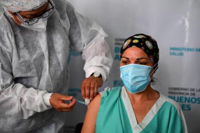  Maria Arriola, a health worker of the Isidoro Iriarte Quilmes Hospital, receive the Sputnik V vaccine jab against the novel coronavirus COVID-19 at this institution in Quilmes, Buenos Aires Province, Argentina, on December 29, 2020. - Argentina on Tuesday launched a COVID-19 vaccination campaign with the Sputnik V shots developed by Russia, the government said. It is the first country in the Americas to use this vaccine against the pandemic. (Photo by Ronaldo SCHEMIDT / AFP)Editoria: HTHLocal: QuilmesIndexador: RONALDO SCHEMIDTSecao: diseaseFonte: AFPFotógrafo: STF<!-- NICAID(14678747) -->