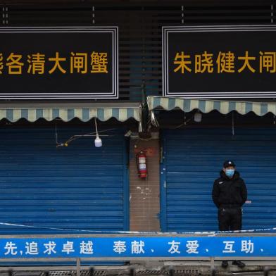 A security guard stands outside the Huanan Seafood Wholesale Market where the coronavirus was detected in Wuhan on January 24, 2020 - The death toll in Chinas viral outbreak has risen to 25, with the number of confirmed cases also leaping to 830, the national health commission said. (Photo by Hector RETAMAL / AFP)<!-- NICAID(14397048) -->