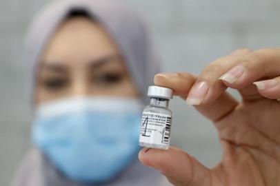 A healthcare worker displays a dose of COVID-19 vaccine at Maccabi Health Services in the Israeli coastal city of Herzliya, north of Tel Aviv, on December 21, 2020. - Israel has ordered 14 million doses of the vaccine -- covering seven million people, as two doses are required per person for optimal protection -- from Pfizer as well as US biotech firm Moderna. (Photo by JACK GUEZ / AFP)<!-- NICAID(14683420) -->