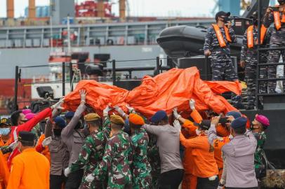 Rescue workers carry recovered debris at the port in Jakarta on January 10, 2021, during the search operation for Sriwijaya Air flight SJY182 which crashed after takeoff from Jakarta on January 9. (Photo by Dany Krisnadhi / AFP)<!-- NICAID(14687096) -->