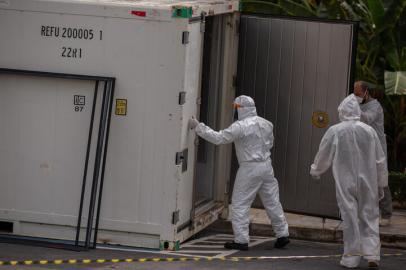 Health workers wear protective suits as they leave a body of a victim of the novel coronavirus in a refrigerated container at the Vinte Oito de Agosto Public Hospital, a unit treating COVID-19 patients in Manaus, Amazonas State, Brazil, on January 4, 2021. - The coronavirus has killed at least 1,843,631 people worldwide since the outbreak emerged in China in December 2019, according to an AFP tally on Monday based on official sources. The US is the worst-affected country with 351,590 deaths, followed by Brazil with 196,018. (Photo by Michael DANTAS / AFP)Editoria: HTHLocal: ManausIndexador: MICHAEL DANTASSecao: diseaseFonte: AFPFot¿grafo: STR<!-- NICAID(14687927) -->