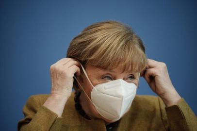 German Chancellor Angela Merkel puts on her face mask after giving a press conference on the Covid-19 situation in Germany at the house of the Federal Press Conference (Bundespressekonferenz), on January 21, 2021 in Berlin. (Photo by Michael Kappeler / POOL / AFP)<!-- NICAID(14699091) -->