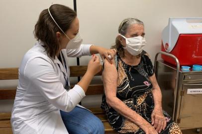 ****EM BAIXA****PORTO ALEGRE, RS, BRASIL, 12/02/2021-  Depois de vacinar centenas de idosos, a enfermeira Roseana Paes, residente em atenção primária pela Secretaria Municipal de Saúde (SMS), aplicou a tão esperada dose: vacinou a avó, Cecília Maria da Silva, 85 anos, no seu posto de trabalho, a US Santa Marta, no centro da Capital, nesta manhã. Foto: Camila Kosachenco  / Agencia RBS<!-- NICAID(14713147) -->