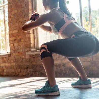 Young fit woman doing squats fitness exercise in gym, rear closeup viewYoung fit sporty active athlete woman wear sportswear crouching doing squats session fitness training legs buttocks muscles workout exercise in modern sunny gym space indoors, rear back close up viewFonte: 317176436<!-- NICAID(14646771) -->