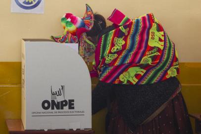 A Quechua indigenous woman dressed in typical ethnic attire marks her ballot at a polling station in the remote rural village of Capachica, in Puno, peru, close to the border with Bolivia, during general elections on April 11, 2021. - Some 25 million Peruvians are set to turn out to vote for a new president and 130 members of the unicameral congress amid the countrys deadliest week of the coronavirus pandemic and a surge in new infections. (Photo by Juan Carlos CISNEROS / AFP)<!-- NICAID(14755196) -->