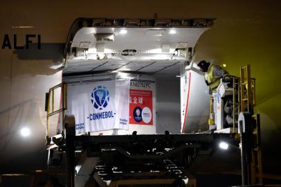 Picture released by adhoc news agency of a worker looking at a container with 50,000 doses of the Chinese Sinovac vaccine against COVID-19 donated to Conmebol inside a Lufthansa airplane upon its landing at the Carrasco International Airport in Ciudad de la Costa, Uruguay, on April 28, 2021. - The vaccines were donated by Chinese laboratory Sinovac to immunize South American football players, who will take part in the Conmebol Copa America and other tournaments. (Photo by Daniel Rodriguez / adhoc / AFP) / Uruguay OUT / RESTRICTED TO EDITORIAL USE - MANDATORY CREDIT AFP PHOTO / ADHOC / DANIEL RODRIGUEZ - NO MARKETING NO ADVERTISING CAMPAIGNS -DISTRIBUTED AS A SERVICE TO CLIENTSEditoria: HTHLocal: Ciudad de la CostaIndexador: DANIEL RODRIGUEZSecao: soccerFonte: adhocFotógrafo: Handout<!-- NICAID(14769957) -->