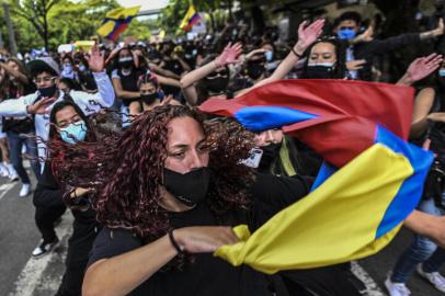 Demonstrators dance during a protest against a tax reform bill launched by President Ivan Duque, in Medellin, Colombia, on May 3, 2021. - President Duque asked the parliament to withdraw a tax reform bill that triggered four consecutive days of protests and riots and announced he will propose a new tax bill reform soon to the congress. (Photo by Joaquin SARMIENTO / AFP)<!-- NICAID(14773876) -->