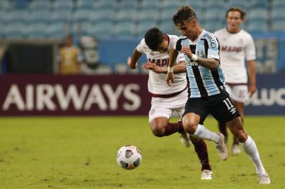 Argentinas Lanus Braian Aguirre (L) and Brazils Gremio Ferreira vie for the ball during the Copa Sudamericana football tournament group stage match at Gremio Arena in Porto Alegre, Brazil, on May 13, 2021. (Photo by SILVIO AVILA / POOL / AFP)Editoria: SPOLocal: Porto AlegreIndexador: SILVIO AVILASecao: soccerFonte: POOLFotógrafo: STR<!-- NICAID(14782970) -->