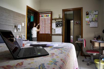 PORTO ALEGRE, RS, BRASIL, 23-04-2021: A professora Adriana Paza em espaco adaptado para as aulas a distancia em casa, na zona sul de Porto Alegre. Ela e professora de uma turma de primeiro ano da Emef Neusa Goulart Brizola e transformou a propria casa em escola para continuar lecionando virtualmente. (Foto: Mateus Bruxel / Agencia RBS)Indexador: Mateus Bruxel<!-- NICAID(14765132) -->