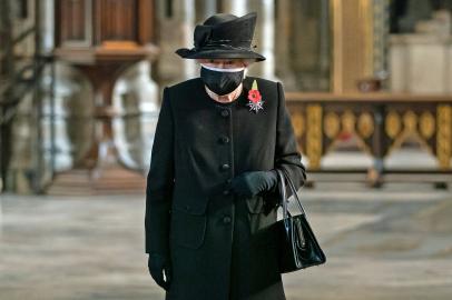 Britains Queen Elizabeth II looks at the grave of the Unknown Warrior during a service to mark the centenary of the burial of the Unknown Warrior ahead of Remembrance Sunday at Westminster Abbey in London on November 4, 2020. - In the small private ceremony, The Queen honoured the Unknown Warrior and the Royal Family¿s own associations with the First World War and the grave at Westminster Abbey. As part of the ceremony, a bouquet of flowers featuring orchids and myrtle - based on Her Majesty¿s own wedding bouquet from 1947 - was placed on the grave of the Unknown Warrior in an act of remembrance. The gesture reflected the custom of Royal bridal bouquets being placed on the grave. (Photo by Aaron Chown / various sources / AFP)