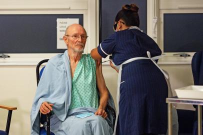 A nurse adminsters the Pfizer-BioNtech Covid-19 vaccine to patient William Bill Shakespeare (L), 81, at University Hospital in Coventry, central England, on December 8, 2020. - Britain on December 8 hailed a turning point in the fight against the coronavirus pandemic, as it begins the biggest vaccination programme in the countrys history with a new Covid-19 jab. (Photo by Jacob King / POOL / AFP)Editoria: HTHLocal: CoventryIndexador: JACOB KINGSecao: preventative medicineFonte: POOLFotógrafo: STR<!-- NICAID(14662834) -->