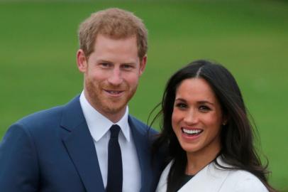 Britains Prince Harry and his fiancée US actress Meghan Markle pose for a photograph in the Sunken Garden at Kensington Palace in west London on November 27, 2017, following the announcement of their engagementBritains Prince Harry will marry his US actress girlfriend Meghan Markle early next year after the couple became engaged earlier this month, Clarence House announced on Monday. / AFP PHOTO / Daniel LEAL-OLIVAS