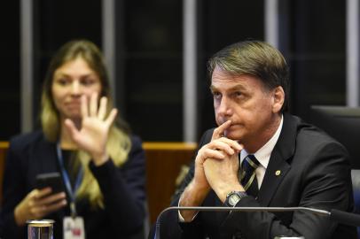 Brazilian far-right president-elect, Jair Bolsonaro (R), gestures during the ceremony celebrating the 30th anniversary of the Brazilian constitution in the National Congress in Brasilia, on November 6, 2018. (Photo by EVARISTO SA / EVARISTO SA / AFP)