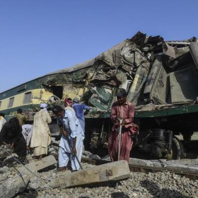 Railway workers try to fix a track beside wreckage of a carriage in Daharki on June 8, 2021, a day after a packed inter-city train ploughed into another express that had derailed, killing at least 63 people. (Photo by Asif HASSAN / AFP)<!-- NICAID(14803316) -->