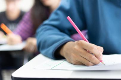 high school,university student study.hands holding pencil writing paper answer sheet.sitting lecture chair taking final exam attending in examination classroom.concept scholarship for education abroadFonte: 313224072<!-- NICAID(14793487) -->