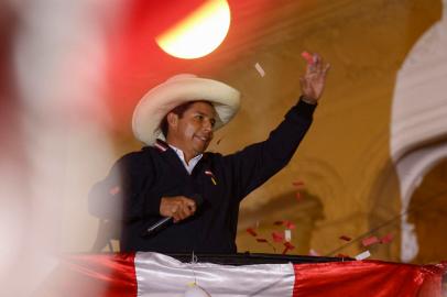 Peruvian leftist presidential candidate Pedro Castillo of Peru Libre waves to supporters from his party headquarters balcony in Lima on June 8, 2021, keeping a narrow lead in the final vote tally with right-wing candidate Keiko Fujimori on Fuerza Popular following the runoff election of June 6. - Peru was on edge Tuesday as right-wing populist Keiko Fujimori cried foul after far-left rival Pedro Castillo took a narrow lead in the final stretch of vote-counting to decide who will be the countrys next president. (Photo by Gian MASKO / AFP)<!-- NICAID(14804967) -->