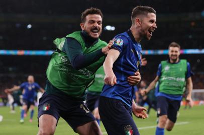 Italys midfielder Jorginho (R) celebrates with Italys defender Alessandro Florenzi after scoring the winning goal in a penalty shootout during the UEFA EURO 2020 semi-final football match between Italy and Spain at Wembley Stadium in London on July 6, 2021. (Photo by Carl Recine / POOL / AFP)Editoria: SPOLocal: LondonIndexador: CARL RECINESecao: soccerFonte: POOLFotógrafo: STR<!-- NICAID(14827597) -->