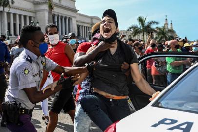 A man is arrested during a demonstration against the government of Cuban President Miguel Diaz-Canel in Havana, on July 11, 2021. - Thousands of Cubans took part in rare protests Sunday against the communist government, marching through a town chanting Down with the dictatorship and We want liberty. (Photo by YAMIL LAGE / AFP)<!-- NICAID(14832158) -->