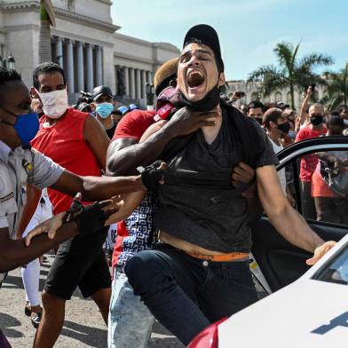 A man is arrested during a demonstration against the government of Cuban President Miguel Diaz-Canel in Havana, on July 11, 2021. - Thousands of Cubans took part in rare protests Sunday against the communist government, marching through a town chanting Down with the dictatorship and We want liberty. (Photo by YAMIL LAGE / AFP)<!-- NICAID(14832158) -->