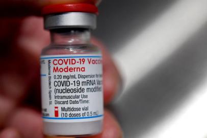 (FILES) In this file photograph taken on June 29, 2021, a medical official holds a vial of the Moderna Covid-19 vaccine in Quimper, western France. - The European medicines watchdog on July 23, 2021, has approved the use of Modernas anti-coronavirus vaccine for children aged 12 to 17, making it the second jab for adolescents for use on the continent. (Photo by Fred TANNEAU / AFP)<!-- NICAID(14843196) -->