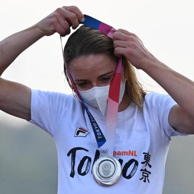 Silver medallist Netherlands Annemiek Van Vleuten puts on her medal on the podium during the medal ceremony for the womens cycling road race of the Tokyo 2020 Olympic Games, at the Fuji International Speedway in Oyama, Japan, on July 25, 2021. (Photo by Greg Baker / AFP)<!-- NICAID(14844290) -->