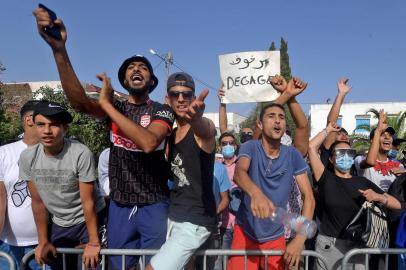 Supporters of Tunisias President Kais Saied chant slogans denouncing the countrys main Islamist Ennahda (Ennahdha) party in front of the Parliament which was cordoned-off by the military in the capital Tunis on July 26, 2021, following a move by the president to suspend the countrys parliament and dismiss the Prime Minister. - Tunisia was plunged deeper into crisis as President Kais Saied suspended parliament and dismissed Prime Minister Hichem Mechichi late July 25, prompting the countrys biggest political party to decry a coup detat. (Photo by FETHI BELAID / AFP)<!-- NICAID(14845025) -->