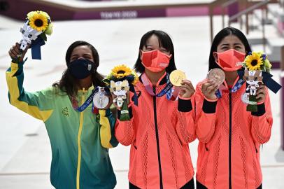 (LtoR) Brazils Rayssa Leal (silver), Japans Momiji Nishiya (gold) and Japans Funa Nakayama (bronze) pose during the medal ceremony of the podium ceremony of the skateboarding womens street final of the Tokyo 2020 Olympic Games at Ariake Sports Park in Tokyo on July 26, 2021. (Photo by Jeff PACHOUD / AFP)Editoria: SPOLocal: TokyoIndexador: JEFF PACHOUDSecao: sports eventFonte: AFPFotógrafo: STF<!-- NICAID(14845194) -->