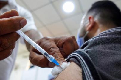 An Iraqi man is inoculated against the COVID-19 coronavirus at a vaccination center in the city of Kufa, 10 kilometres (about 6 miles) northeast of the central city of Najaf, on July 25, 2021. (Photo by Ali NAJAFI / AFP)<!-- NICAID(14845612) -->